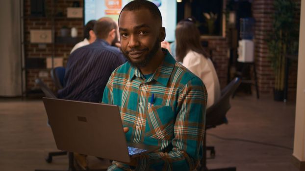 African american office employee working on laptop portrait