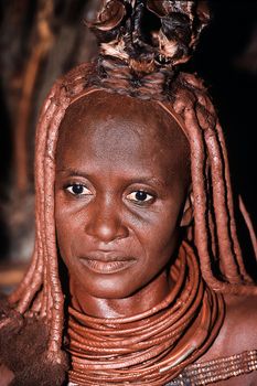 May 15, 2005. portrait of unidentified Himba woman  with the traditional hairstyle, necklace and the typical ochre tinted skin. Epupa Falls, Kaokoland or Kunene Province, Namibia, Africa