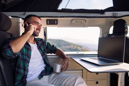 man inside his camper van talking on mobile phone