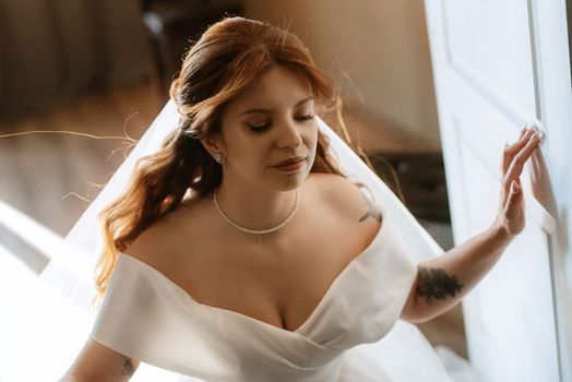 portrait of a bride girl with red hair in a white wedding dress