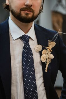 portrait of a male groom in a blue suit in the morning  barbershop