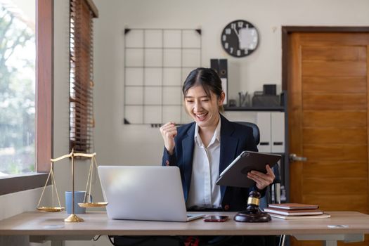 Asian business lawyer are excited about celebrating business success with inspiration from their excellent financial results that are happy working in a modern office on a computer