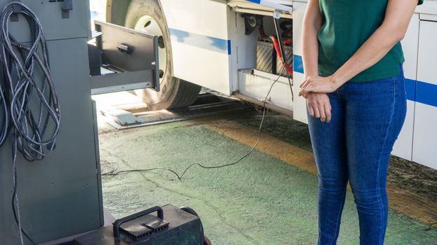 Unrecognizable Latin woman mechanic checking the proper functioning of a bus