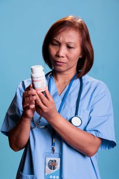 Serious medical assistant working at medication treatment to prevent patient sickness