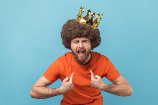 Man in golden crown and pointing himself with excite expression, looking with arrogance.