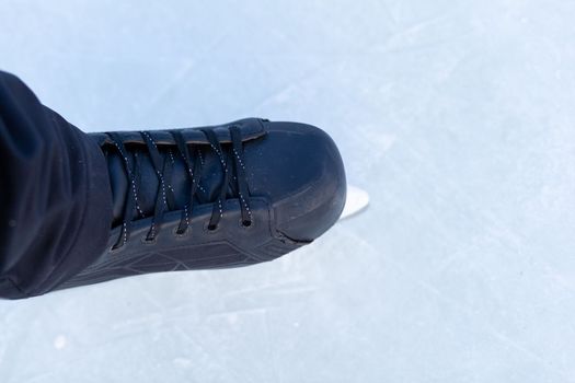 A pair of hockey skates with laces on frozen ice close-up