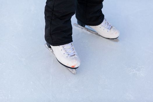 A pair of hockey skates with laces on frozen ice close-up
