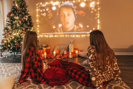 Beautiful teen girls watching new year movie on christmas eve