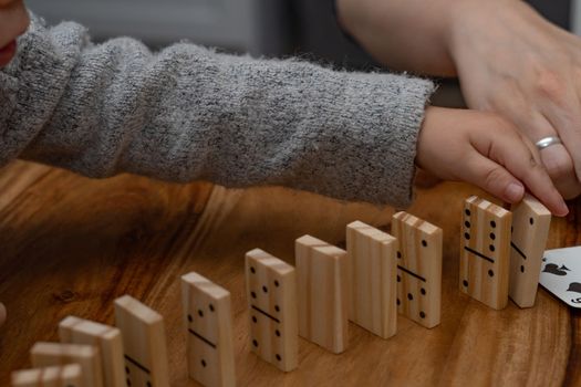 child's hands playing dominoes with blurred focus