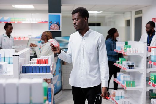 African american man buying heart supplements in drugstore