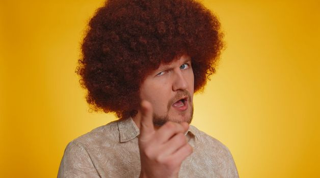 Man afro hairstyle shakes finger and saying no, be careful, avoid danger mistake, disapproval sign