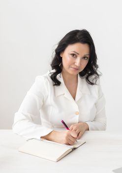 Indian woman beautician or doctor takes notes in office - cosmetologist business woman or doctor concept