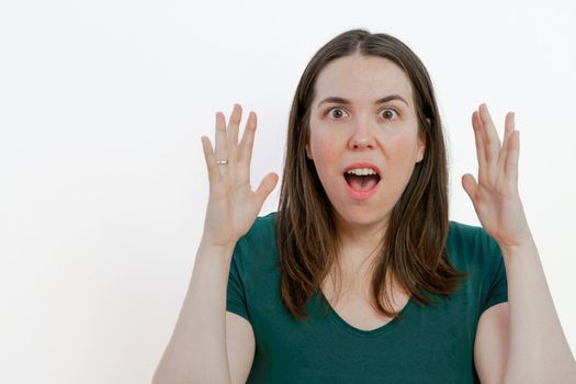open-mouthed brunette woman surprised with raised arms
