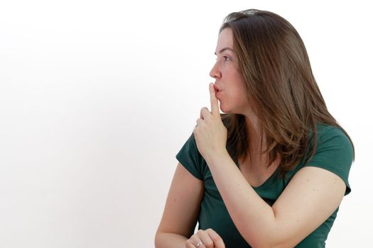 woman in profile with finger in mouth asking for silence