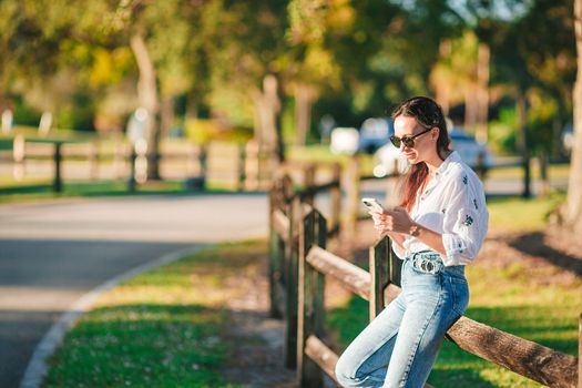 Young woman using mobile phone outdoor in the park