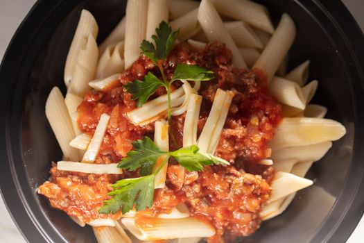 Pasta Penne with Tomato Bolognese Sauce, Parmesan Cheese and Basil.
