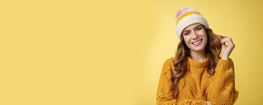 Charming feminine flirty girl seek rich guy during winter vacation mountains ask instructor coquettish teach snowboarding gazing camera seducing rolling curl index finger, yellow background