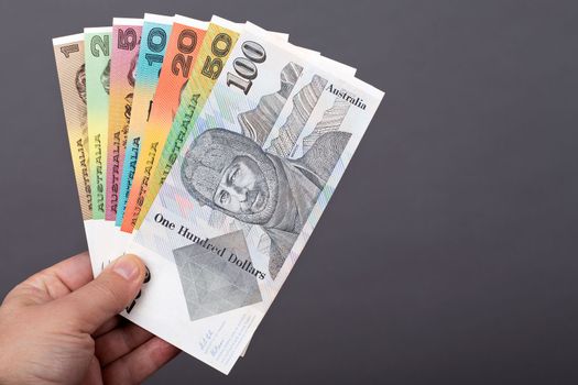 Old Australian money in the hand on a gray background