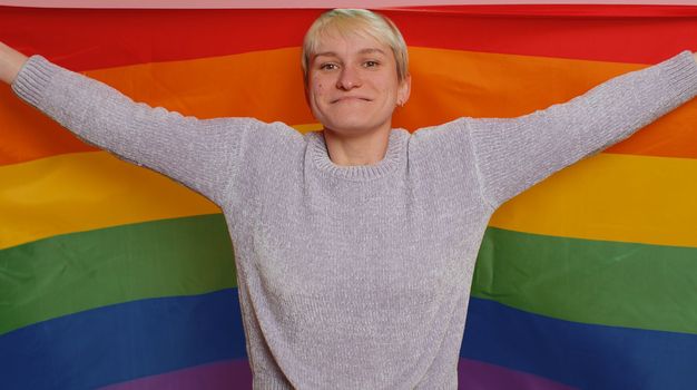 Woman with short hair with rainbow LGBT flag celebrate parade show tolerance same sex marriages