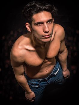 Anguished shirtless muscular young man in dramatic pose