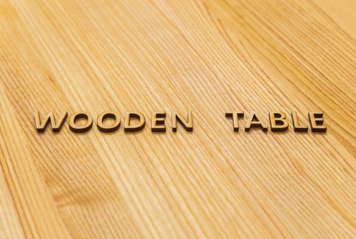 The inscription "wooden table" on the oak table top. Background