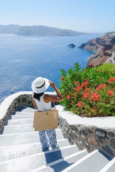 Asian woman visit Oia Santorini Greece during summer with whitewashed homes and churches