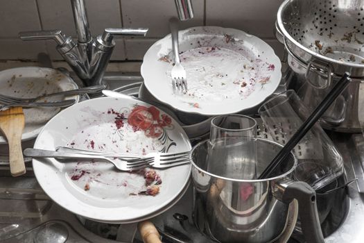 A pile of dirty dishes in a kitchen sink
