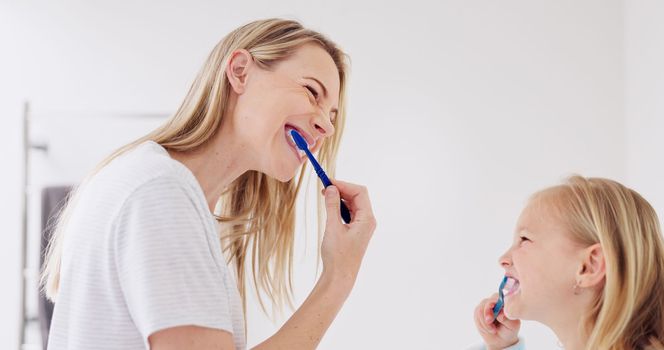 Toothbrush, mother and girl cleaning their teeth in the morning in the bathroom of their family home. Happy, bond and mom doing a dental hygiene routine for health with oral products with her child.