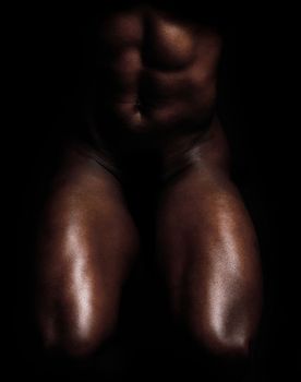 Fit, strong and muscular man isolated against black background and posing nude, bare or topless. Closeup of powerful, active or athletic bodybuilder showing muscles, sensual body and male physique