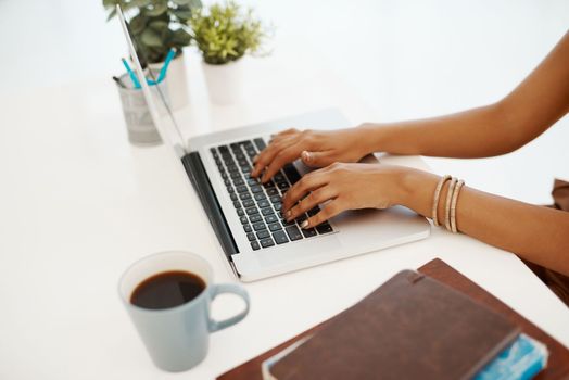 Stay connected, stay productive. a businesswoman using a laptop at her desk in a modern office.