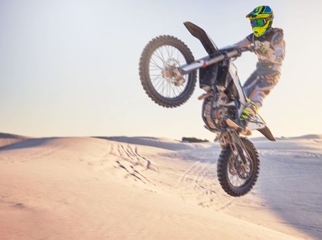 Motorcycle jump, sports outdoor with exercise in desert, stunt for extreme sport, speed and helmet for safety. Challenge, freedom and athlete biking, fitness mockup and person training with dirt bike