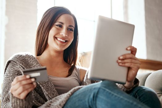 Woman, online shopping and digital tablet with credit card on sofa for payment on ecommerce sale. Girl, debit card and booking online, credit score and easy purchase of convenience in a living room