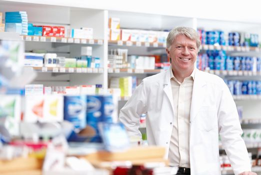 Male pharmacist at drugstore. Portrait of mature male pharmacist smiling at drugstore.