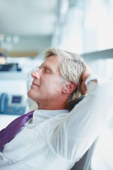 Business man relaxing after work. Side view of mature business man resting at work.