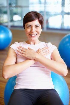 Woman smiling during workout. Portrait of fit woman smiling while working out on pilates ball.
