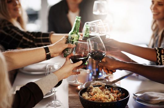 Cheers to making friendship a priority. a group of young friends making a toast at a dinner party.