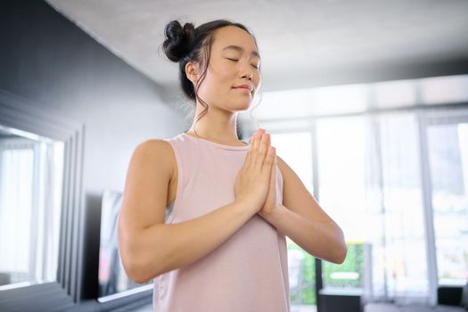 Yoga, meditate and woman with gratitude for her mind, peace and calm start to the morning. Hope, freedom and Asian girl in the living room for a mindset exercise, spiritual faith and mindfulness