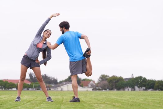 My best workout partner. two people helping each other stretch on a grassy field.