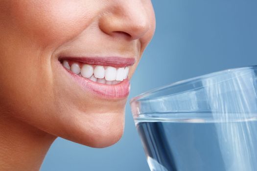 Detail view of a woman female drinking a glass of water. Detail view of a young pretty female drinking a glass of water.