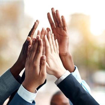 Anything is possible if we stick together. Closeup shot of a group of unrecognizable businesspeople high fiving each other.