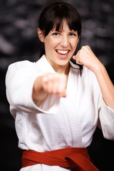 Packing a powerful punch. Portrait of a young woman practicing karate in her gi.