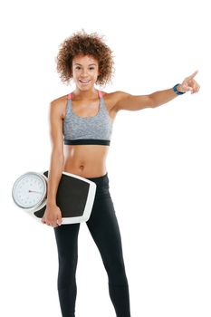 Your attitude determines your direction. Studio portrait of a fit young woman holding a scale against a white background.
