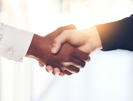 The start of a new partnership. Closeup shot of two unidentifiable businesspeople shaking hands in an office.