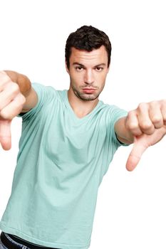 Man, hands and thumbs down standing in disappointment for fail, wrong or disagree against white studio background. Portrait of isolated young male casual model pointing thumb down on white background