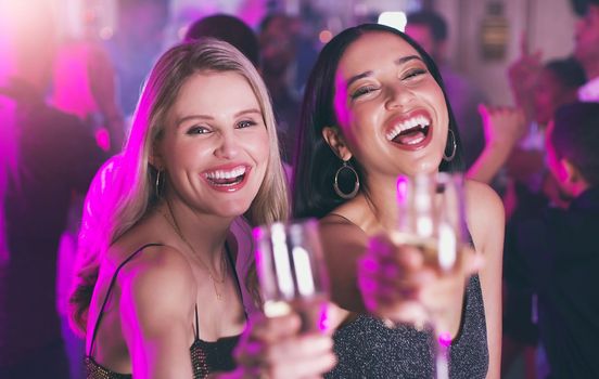Portrait, party and toast with woman friends in a nightclub for a new year celebration together. Birthday, event and cheers with a young female and friend bonding while clubbing or at a dance