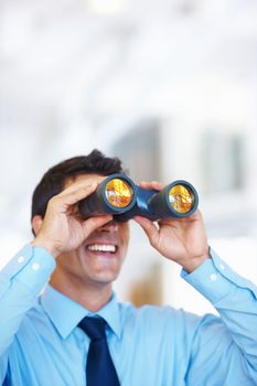 Business tactician. Portrait of attractive young business man using binoculars.