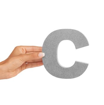 Showing you the letter C. A young woman holding a capital letter C isolated on a white background.