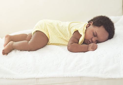 Babies need lots of rest. a baby girl asleep on a bed at home.