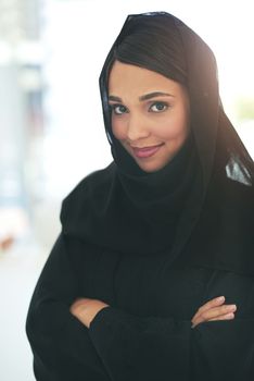 Im here to achieve my ambitious goals. Portrait of a confident young muslim businesswoman working in a modern office.