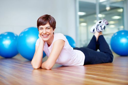 Beautiful woman smiling. Portrait of beautiful woman lying on the gym floor and smiling.
